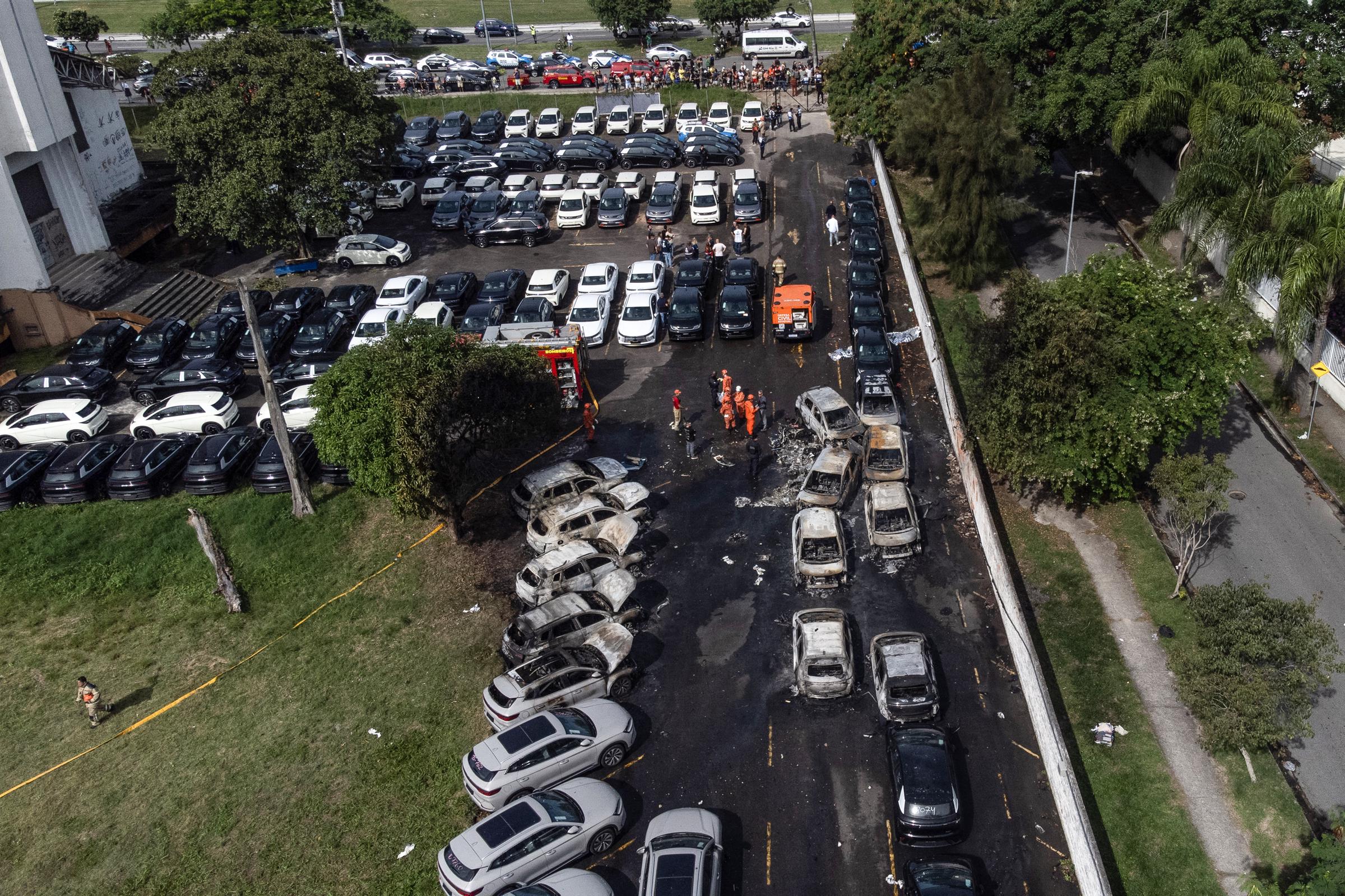 An aerial view shows burned vehicles at a car dealership in Rio de Janeiro, Brazil, on June 14, 2026, after a helicopter crashed into the parking lot following a midair collision. | Source: Getty Images
